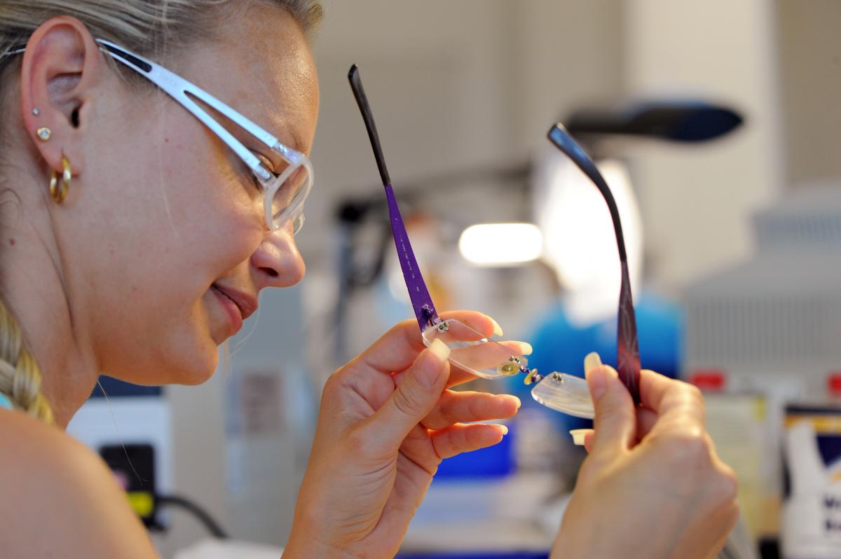 Optician Linda Bajerski mounts lenses into rimless glasses at Essilor Lenses in Rathenow, Germany